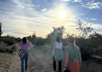 Three women on a retreat waling in the desert